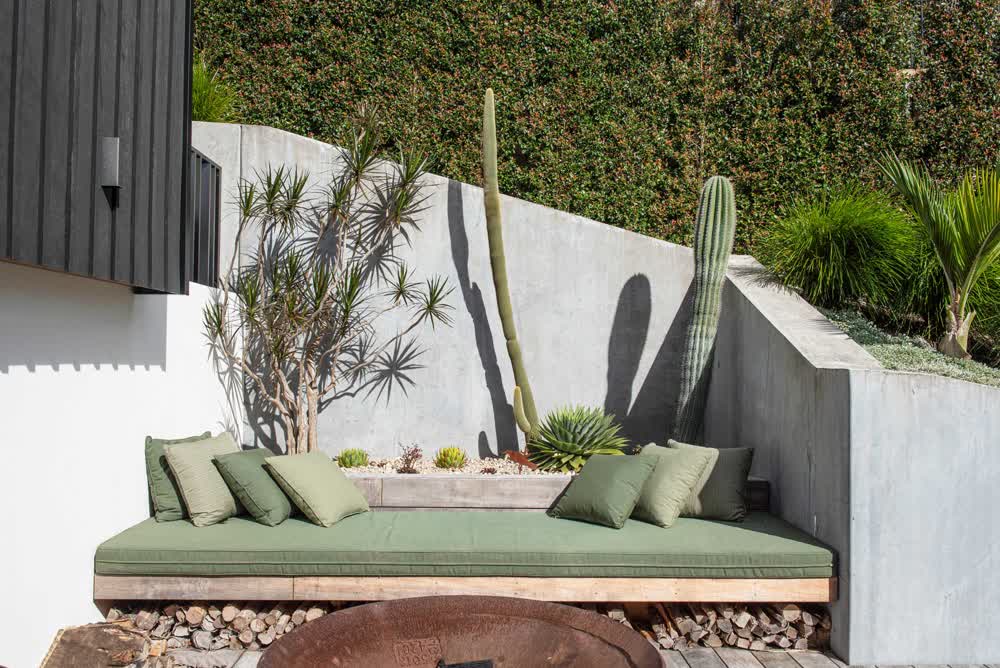 Concrete wall with built-in firepit seating and wood storage