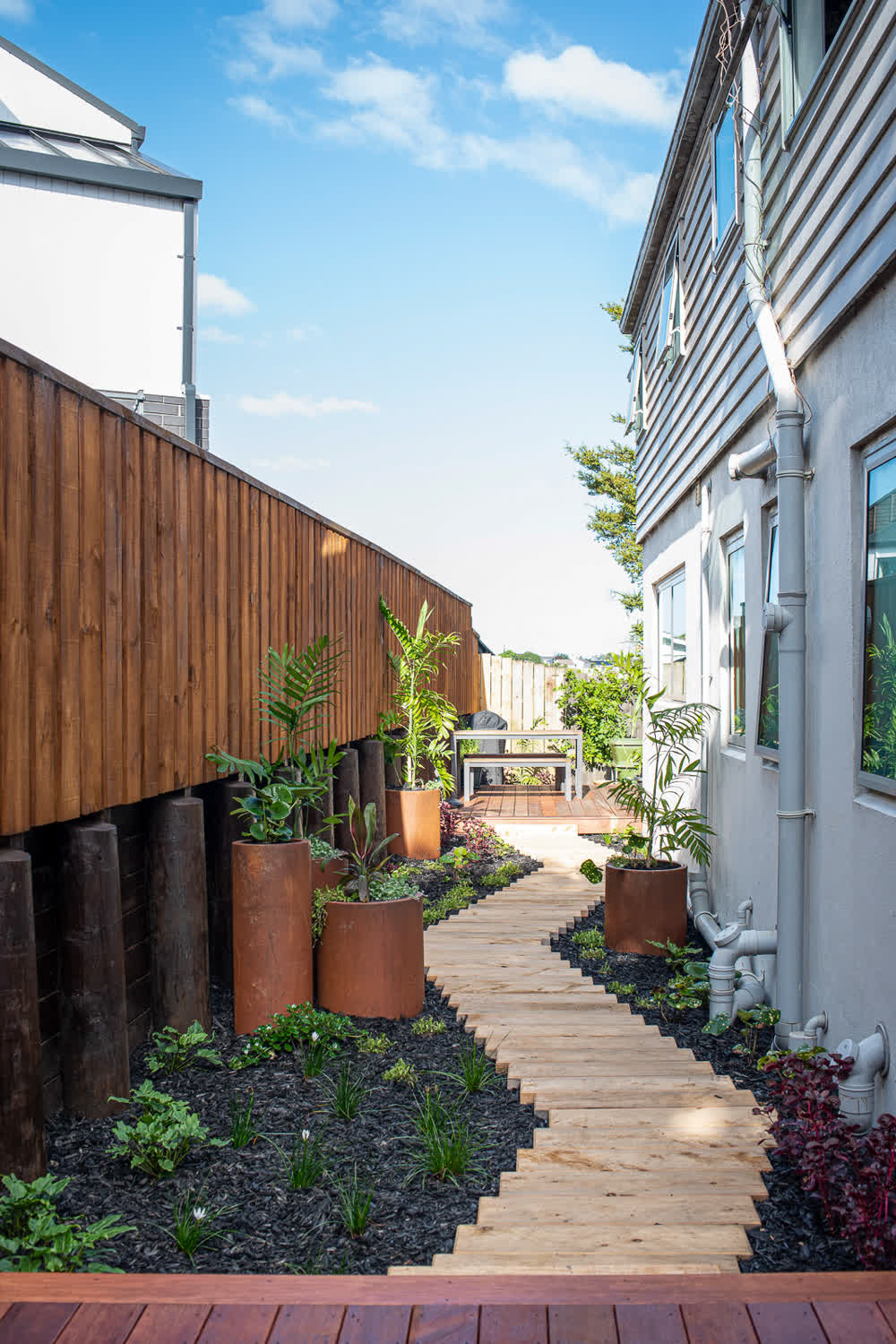 Staggered wooden path beside retaining wall with fence