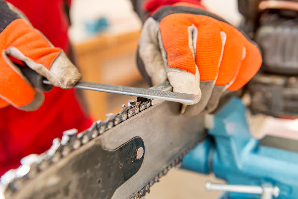 A close up shot of a chainsaw being sharpened