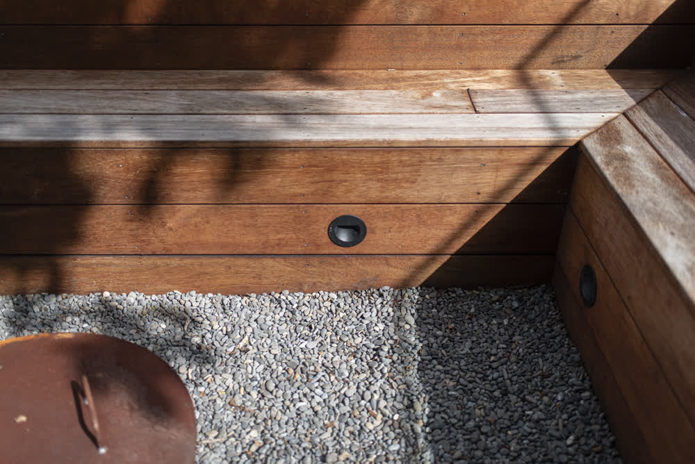Close-up of stained wooden corner seating on stone base